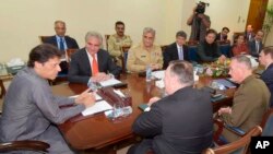 In this photo released by Pakistan's Press Information Department, Pakistan's Prime Minister Imran Khan, left, meets with visiting U.S. Secretary of State Mike Pompeo, front, in Islamabad, Pakistan, Sept. 5, 2018.