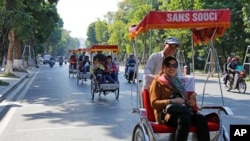 FILE - Chinese tourists ride rickshaws for sightseeing in Hanoi, Vietnam.