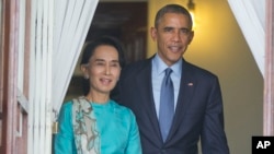 FILE - President Barack Obama walks out with Myanmar's Aung San Suu Kyi at her home before the start of their joint news conference in Yangon, Myanmar. 
