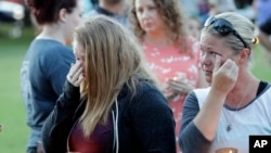 Santa Fe High School freshman Kylie Trochesset, left, and her mother, Ashlee, wipe away tears during a prayer vigil following a shooting at Santa Fe High School in Santa Fe, Texas, May 18, 2018.