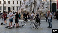 Warga yang keluar rumah tampak berkumpul di Piazza Navona kota Roma, saat pembatasan Covid-19 mulai dilonggarkan di Italia. 