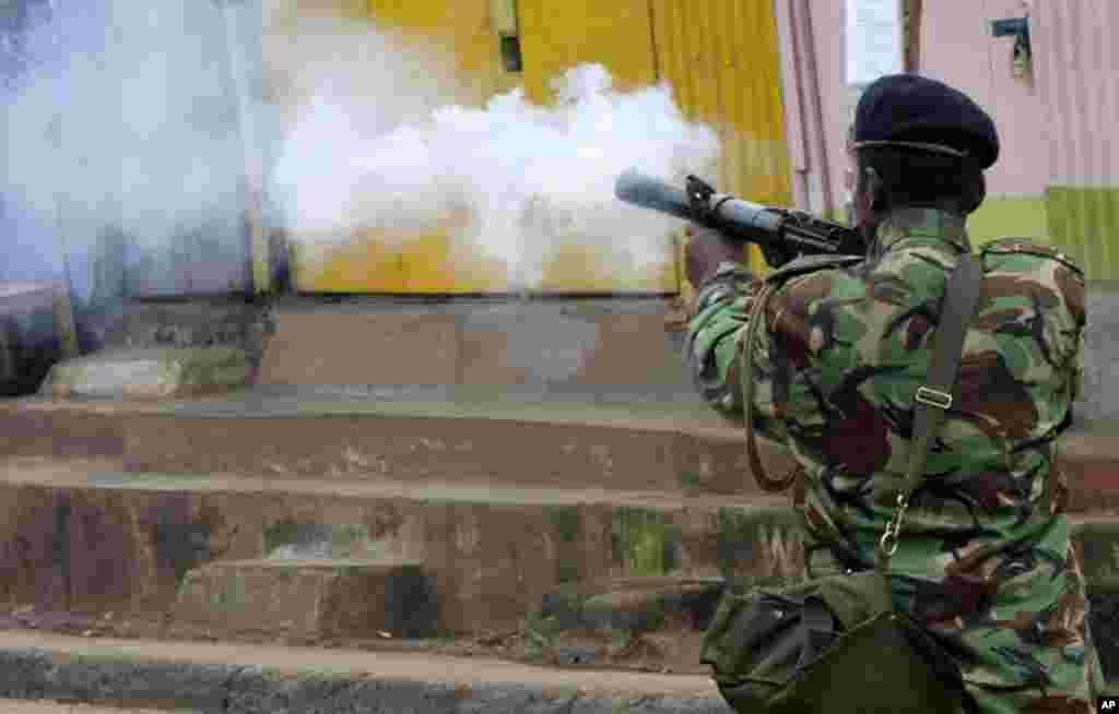 Un officier de police tire une grenade lacrymogène à Kibera, Kenya, 23 mai 2016.