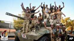 U.S.-backed forces celebrate re-taking Sirte, Libya from the Islamic State group Thursday, Aug. 11, 2016. They have liberated "70 percent" of the city of Sirte, the Islamic State group's last bastion in the North African country.