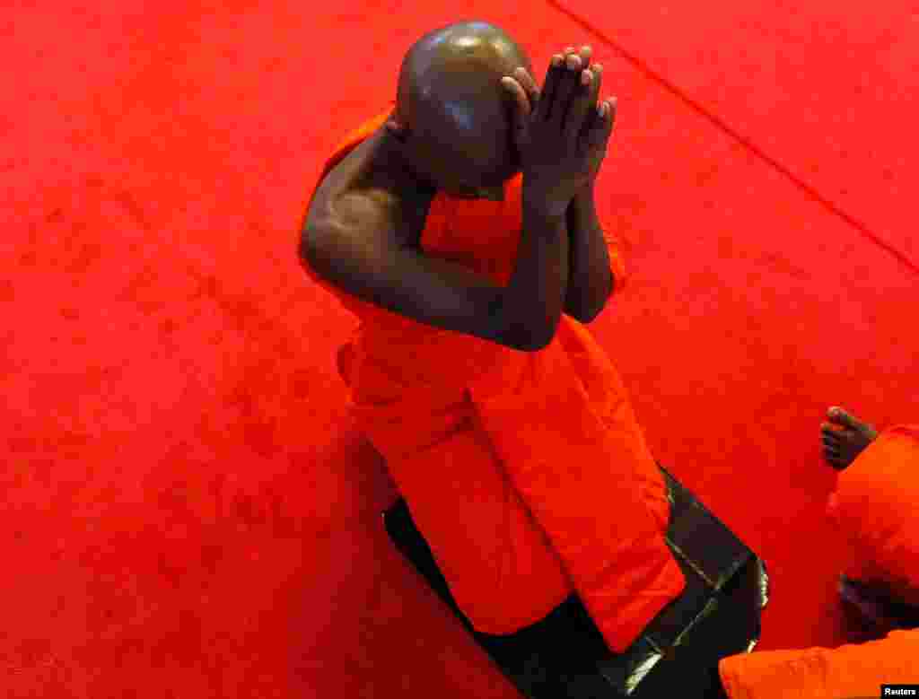 A newly ordained Buddhist monk prays during a ceremony of Upasampada, a Buddhist rite of higher ordination by which a novice becomes a monk, or bhikhu, at a Buddhist temple in Colombo, Sri Lanka.