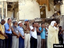 FILE - U.N. staff are led in prayer by an Imam in front of the devastated former U.N. headquarters in Baghdad, during a memorial service on Aug. 30, 2003. The bomb on Aug. 19 killed 22 people, including U.N. envoy Sergio Viera de Mello.
