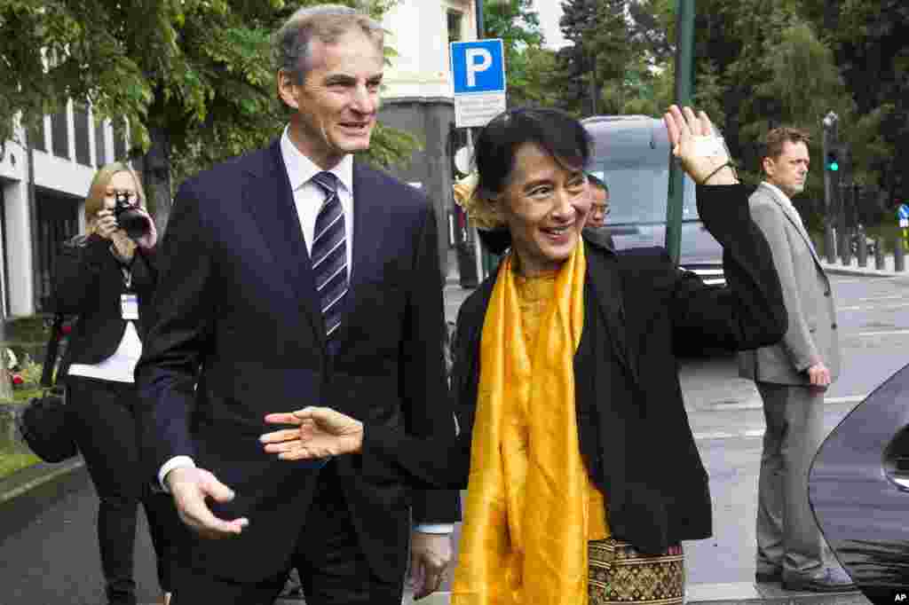 Menteri Luar Negeri Norwegia Jonas Gahr Store (kiri) menyambut Aung San Suu Kyi di Departemen Luar Negeri Norwegia di Oslo, Minggu (17/6).