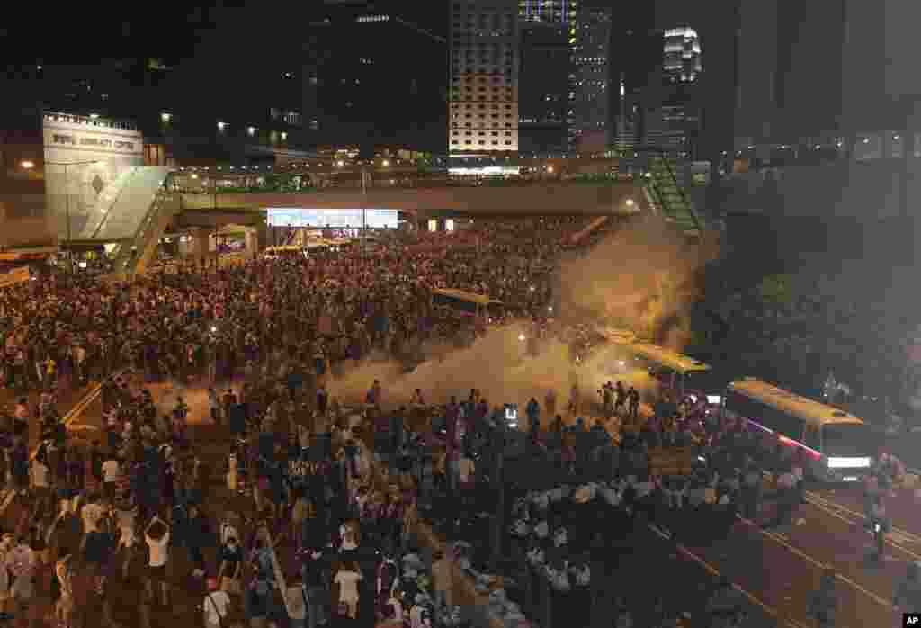 Riot police use tear gas against protesters after thousands of people blocked a main road at the financial central district in Hong Kong. 