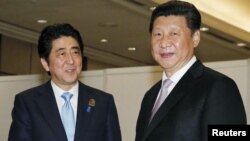 習近平(右)2015年4月在雅加達出席亞非首腦會議期間會晤日本首相安倍晉三。(資料照)