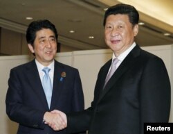 中国国家主席习近平（右）与日本首相安倍在印尼雅加达会面（2015年4月22日）