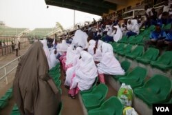 Female rugby players, who wear hijab on top of their uniforms, in Kano State, Nigeria, a predominantly Muslim state, wait their turn to play at the tournament. (VOA / C. Oduah)