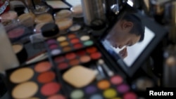 FILE - A man is reflected on a mirror as he does his make-up before giving a performance at the "Divas in Paradise" themed party organized by Beijing LGBT Center at the W Hotel Chang'an in Beijing, China.