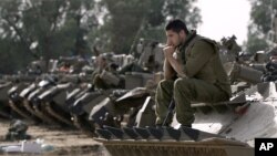 Israeli soldiers with armored vehicles gather in a staging ground near the border with Gaza Strip, southern Israel, Friday, Nov. 16, 2012. 