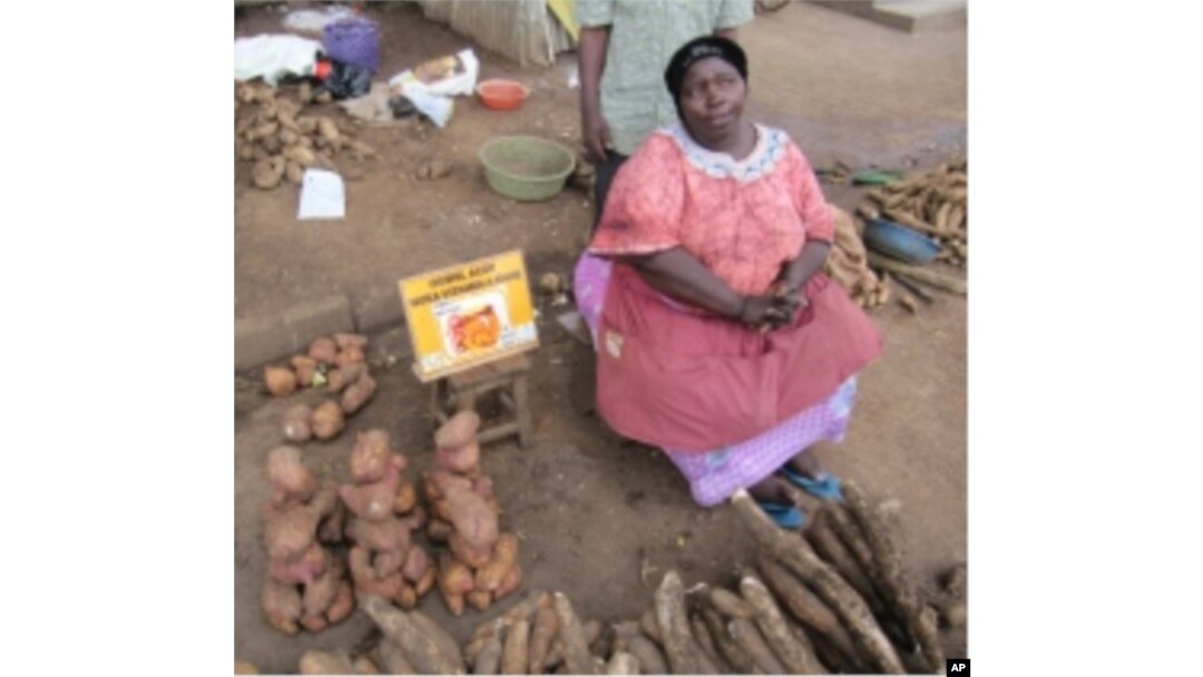 A market vendor in Uganda promotes vitamin A-rich orange sweet potatoes.