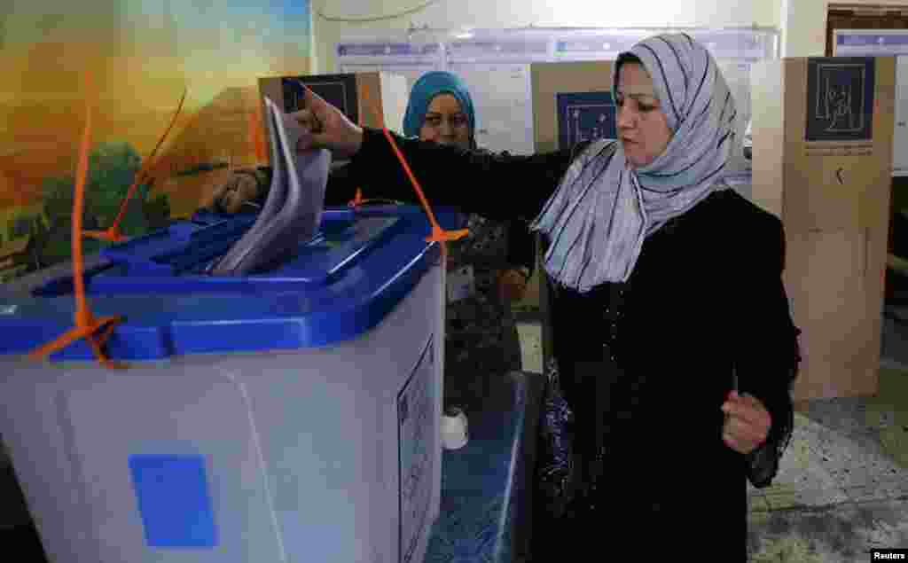 A resident casts her vote at a polling station during parliamentary election in Baghdad, April 30, 2014.