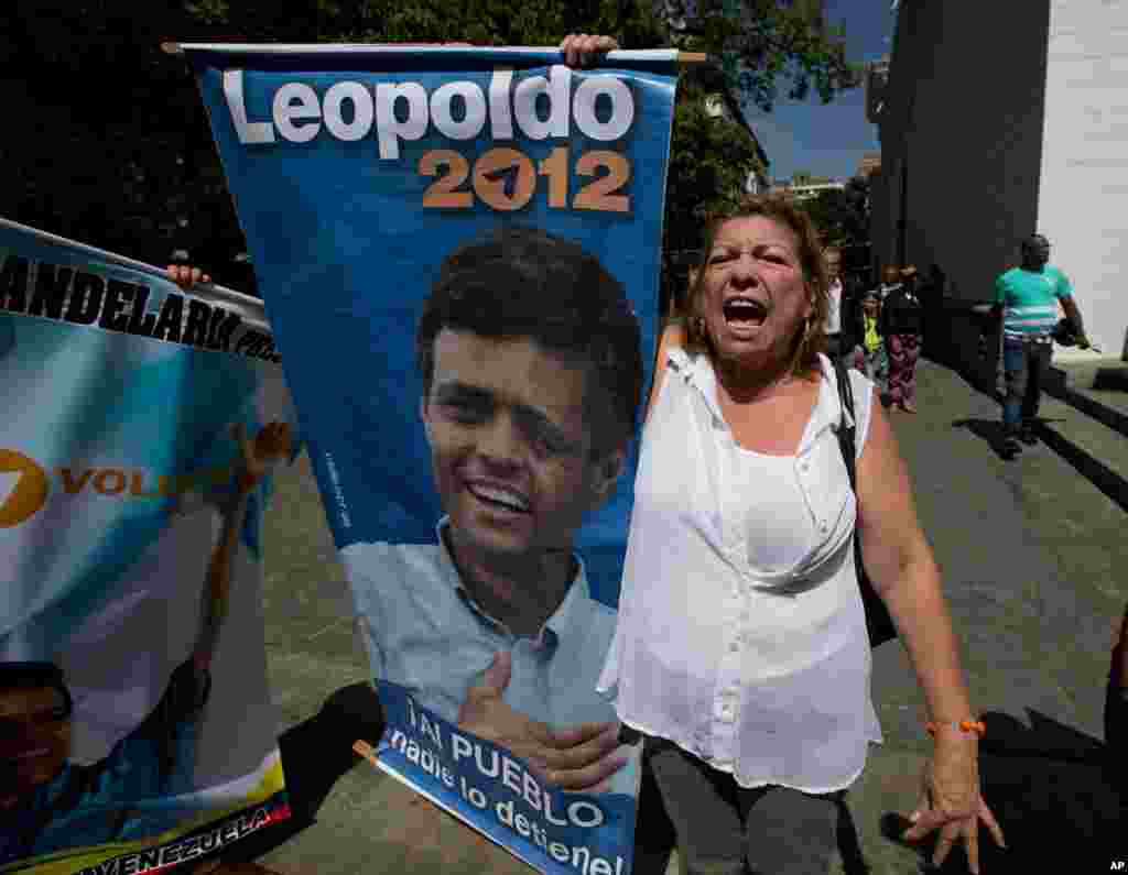 Seorang pendukung Leopoldo Lopez meneriakkan &quot;Bebaskan Leopoldo&quot; sambil membawa poster di luar pengadilan di Caracas, Venezuela. Sidang 19 bulan pemimpin oposisi itu hampir berakhir sementara politisi yang dipenjara itu bersiap untuk menyampaikan pidatonya di pengadilan yang tertutup untuk umum.