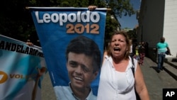 FILE - A supporter of Leopoldo Lopez shouts "Freedom for Leopoldo" while holding his poster outside court in Caracas, Venezuela.