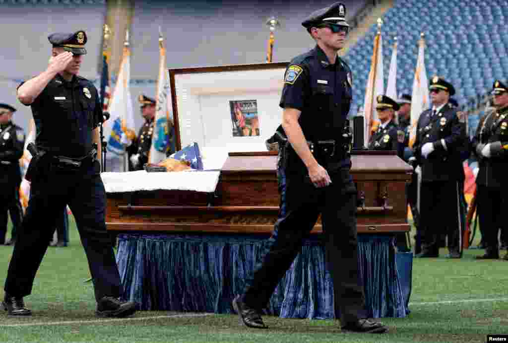 Police officers salute the casket of K-9 Kitt in Gillette Stadium during a memorial service held in honor of the police dog, who was killed during a domestic violence call, in Boston, Massachusetts, June 22, 2021.