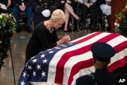 Cindy McCain, viuda del senador John McCain, se reclina sobre el ataúd del senador John McCain en el Capitolio en Washington, el viernes, 31 de agosto de 2018.