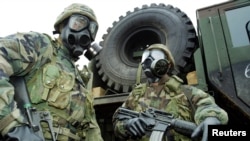 U.S. soldiers wear gas masks as they take part in a chemical, biological and radiological warfare exercise.