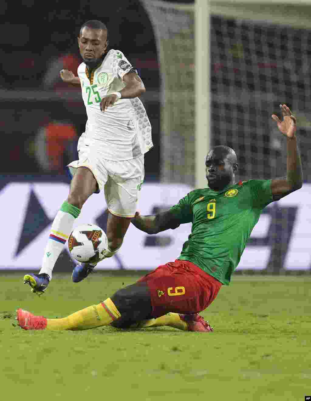 Comoros&#39; Moussa Djoumoi, jumps as he avoids a sliding tackle attempt from Cameroon&#39;s Stephane Bahoken.