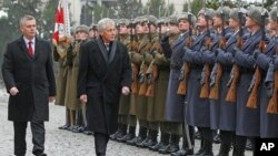 FILE - US Secretary of Defense Chuck Hagel (center) and Polish Defense Minister Tomasz Siemoniak inspect a military honor guard during a welcoming ceremony in Warsaw, Jan. 30, 2014. 
