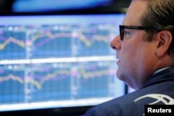 FILE - A trader works on the floor of the New York Stock Exchange shortly after the opening bell in New York, U.S., July 31, 2018.