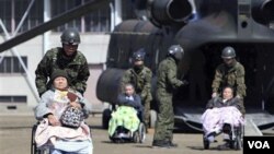 Soldados japoneses realizan tareas de evacuación, movilizando a los ancianos a lugares seguros y con mejor atención.