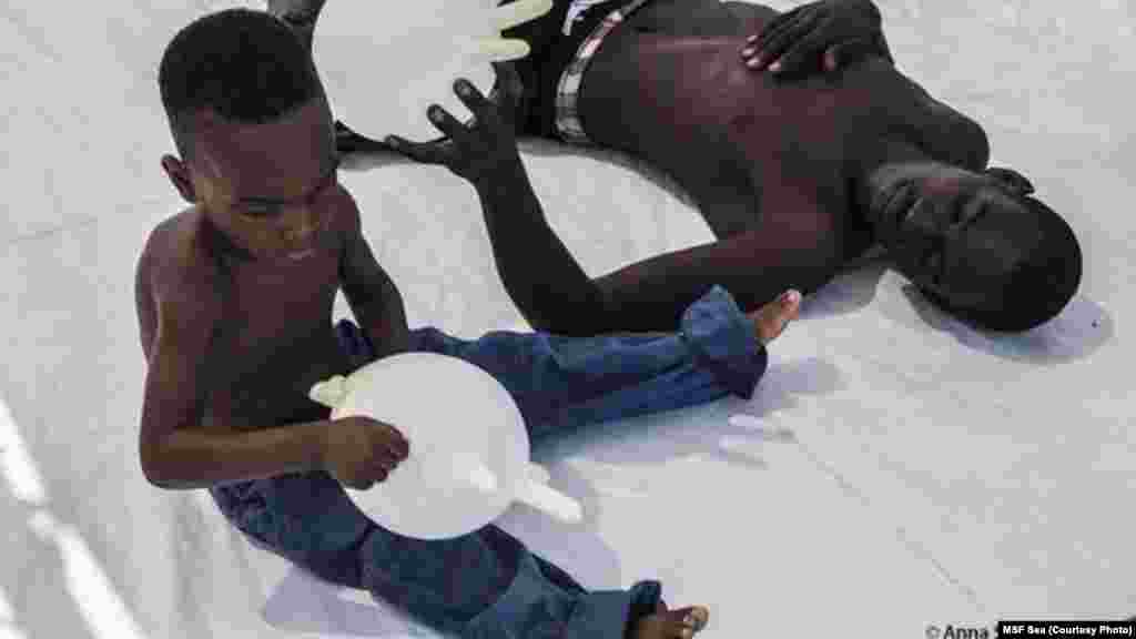 Un père essaie de distraire son enfant pour l’aider à oublier tout l’effroi qu’ils ont connus le long de leur aventure.