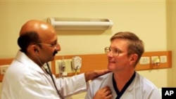 Indian doctor Praveen Chandra checks on an American patient Greg Goodell from Iowa after a his successful heart operation at a hospital in New Delhi, India, Saturday, Oct. 21, 2006,