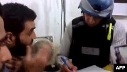 An image grab taken from a video posted by Syrian activists on Aug. 26, 2013 allegdly shows a UN inspector (R) listening to the testimony of a man in the Damascus subburb of Moadamiyet al-Sham.