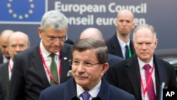 Le Premier ministre turc, Ahmet Davutoglu, centre, arrive à Bruxelles pour le sommet de l'UE sur la crise migratoire, le vendredi 18 mars 2016. (AP Photo/Geoffroy Van der Hasselt)
