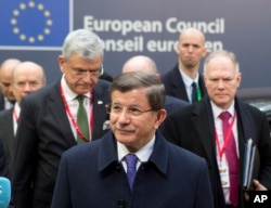 Turkish Prime Minister Ahmet Davutoglu, center, arrives for an EU summit in Brussels on Friday, March 18, 2016.