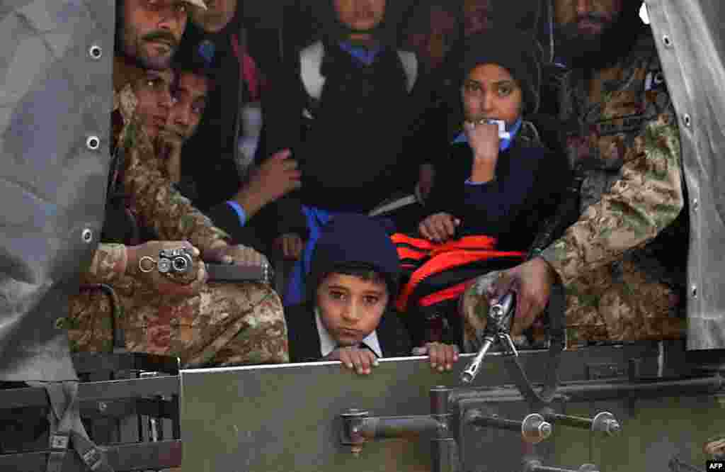 Des soladts pakistanaise transportent des élèves qui ont échappé à l&#39;attaque d&#39;uune école par des hommes armés talibans à Peshawar le 16 décembre 2014.