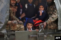 FILE - Pakistani soldiers transport rescued schoolchildren from the site of an attack by Taliban gunmen on a school in Peshawar, Dec. 16, 2014.
