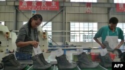 FILE - People work on the assembly line at a shoe factory in Dukem, Ethiopia, April 19, 2012. (SFP Photo)