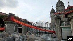 2014年7月16日浙江省增山村基督教教会教友在教堂门口堆积岩石以防政府工作人员拆除十字架