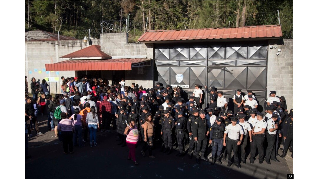 National Police guard the entrance to the children's shelter Virgin of the Assumption Safe Home where people gather in San Jose Pinula, Guatemala, March 8, 2017.