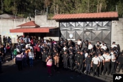 National Police guard the entrance to the children's shelter Virgin of the Assumption Safe Home where people gather in San Jose Pinula, Guatemala, March 8, 2017.