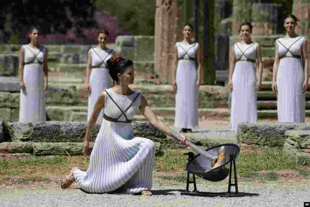 Aktris Yunani Katerina Lehou, meyalakan obor Olimpiade, dalam latihan penyalaan obor Olimpiade di kota kuno Olympia, Yunani. Obor Olimpiade ini nantinya akan dibawa estafet menuju kota Rio de Janeiro, Brazil yang akan menjadi tuan rumah Olimpiade pada 5-21 Agustu 2016.