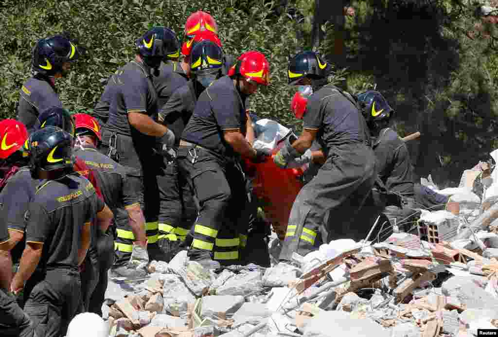 A body is carried away by rescuers following an earthquake in Amatrice, central Italy, Aug. 25, 2016. 