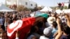 FILE - Mourners carry the coffin of slain opposition politician Mohamed Brahmi during part of his funeral procession in Tunis, Tunisia, July 27, 2013. On Tuesday, a Tunisian court sentenced eight defendants to death over the 2013 assassination.of the leftist opposition leader.