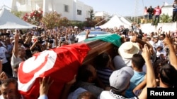 FILE - Mourners carry the coffin of slain opposition politician Mohamed Brahmi during part of his funeral procession in Tunis, Tunisia, July 27, 2013. On Tuesday, a Tunisian court sentenced eight defendants to death over the 2013 assassination.of the leftist opposition leader.