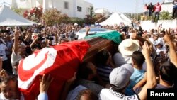 Mourners carried the coffin of slain opposition politician Mohamed Brahmi during part of his funeral procession in Tunis July 27, 2013.