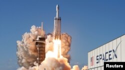 A SpaceX Falcon Heavy rocket, carrying the Arabsat 6A communications satellite, lifts off from the Kennedy...