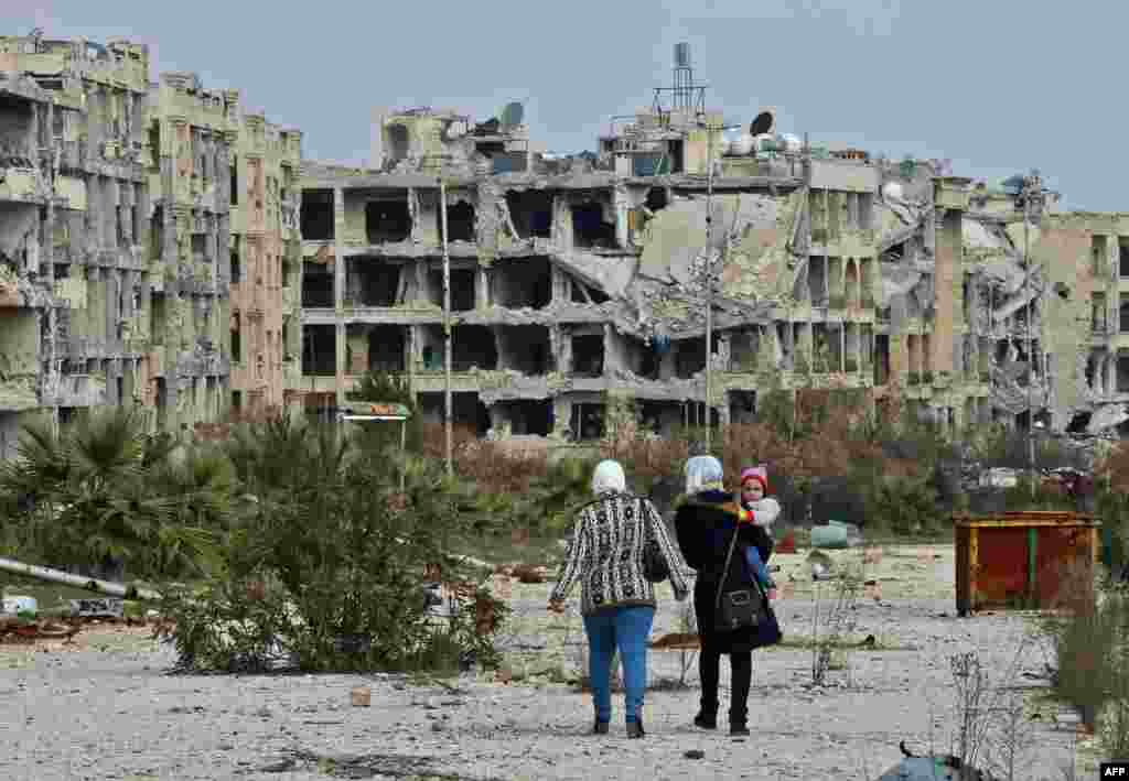 People who live in a neighborhood on the edge of the northern Syrian city of Aleppo return to their homes to check the damage caused by fighting between regime forces and rebel fighters.