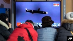 People watch a TV showing a file image of North Korea's missile launch during a news program at the Seoul Railway Station in Seoul, South Korea, Jan. 25, 2022.