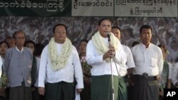 Aung Thein Lin, center, a retired Yangon mayor accompanied by Aung Win, second from left, a candidate of government backed Union Solidarity and Development Party (USDP), speaks to supporters during an election campaign in Dagon Port township, in Yangon, 