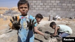 Syrian refugee children play with clay after workers end work at Al Zaatri refugee camp in the Jordanian city of Mafraq, near the border with Syria, September 2, 2012.