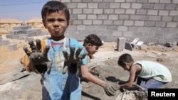 Syrian refugee children play with clay after workers end work at Al Zaatri refugee camp in the Jordanian city of Mafraq, near the border with Syria, September 2, 2012.