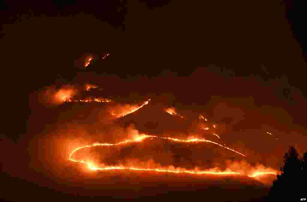 Flames and smoke rise from a forest fire near Sarande in the Muzina mountain region, southern Albania, Aug. 9, 2017.